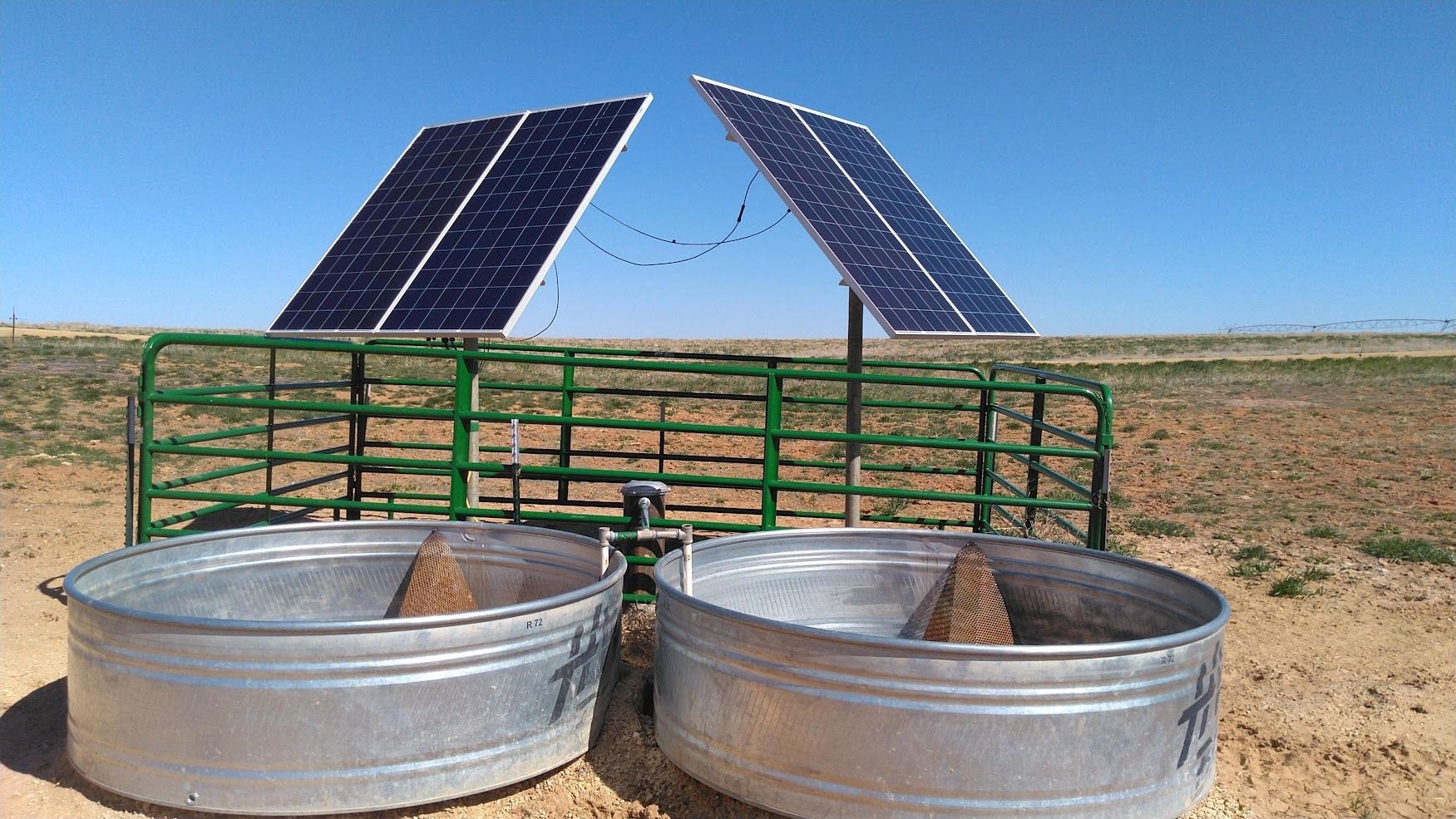 A solar pump well with solar panels and water troughs in colorado