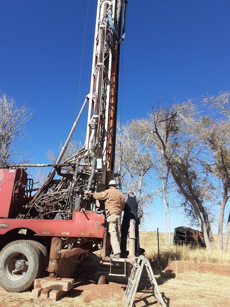 Two men working on a red drilling rig in colorado